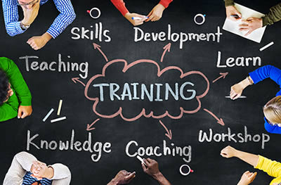 Image of people around a chalkboard-like table with the word "TRAINING" in the center
