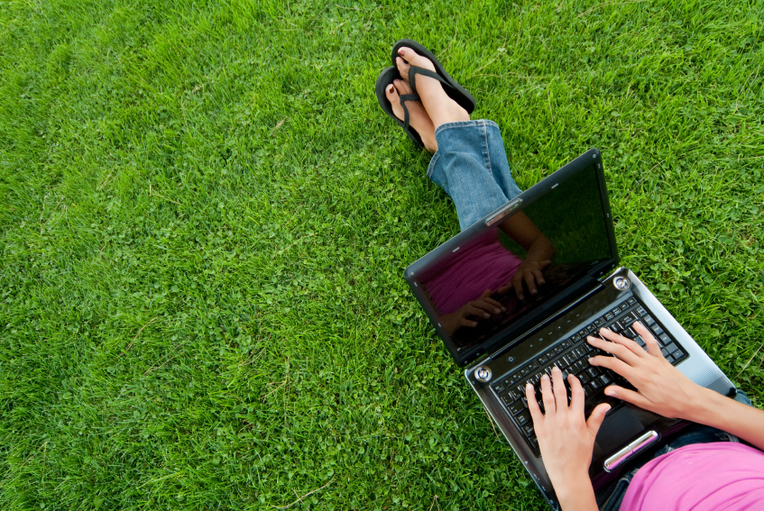 woman laptop on lap in grass