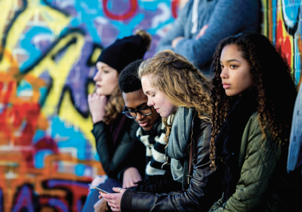 Teenagers sitting in front of alley wall