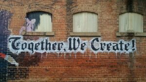 Together We Create graffiti on brick building