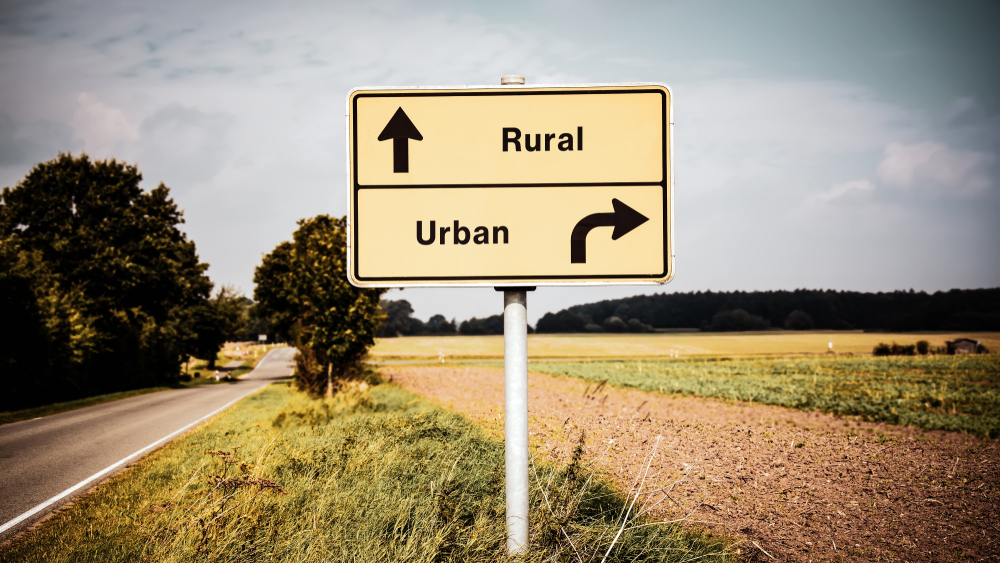 Rural - Urban road sign in middle of farm field